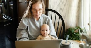 mom using laptop with baby on her lap - chatgpt for medical advice